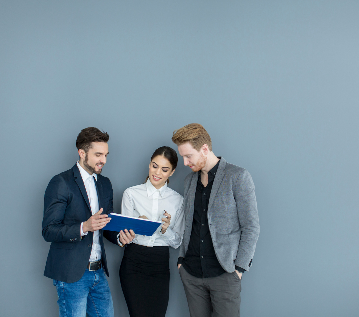 Three business professionals discussing a document, symbolizing teamwork, collaboration, and shared goals.