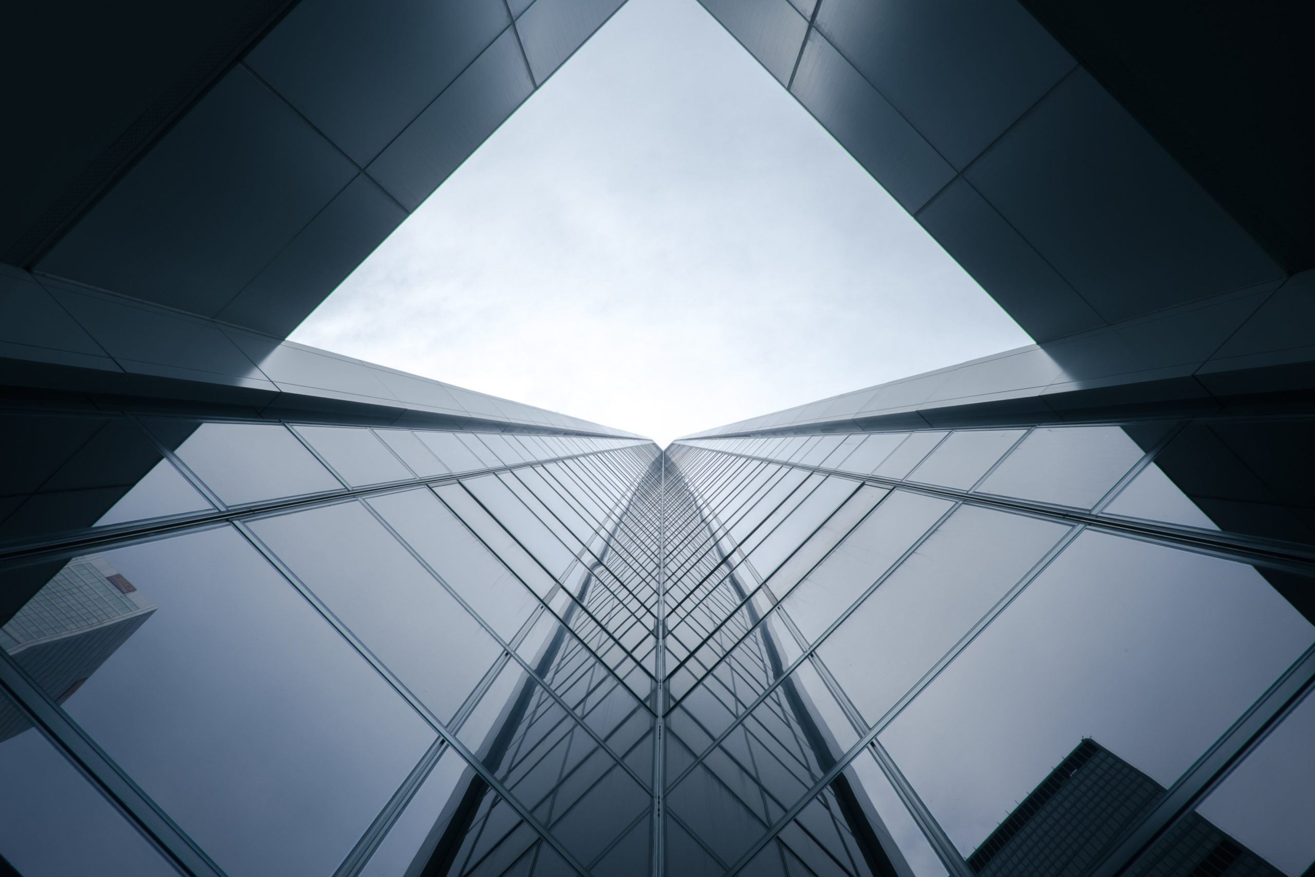 Upward view of a sleek modern glass building, symbolizing innovation, sustainability, and corporate progress.